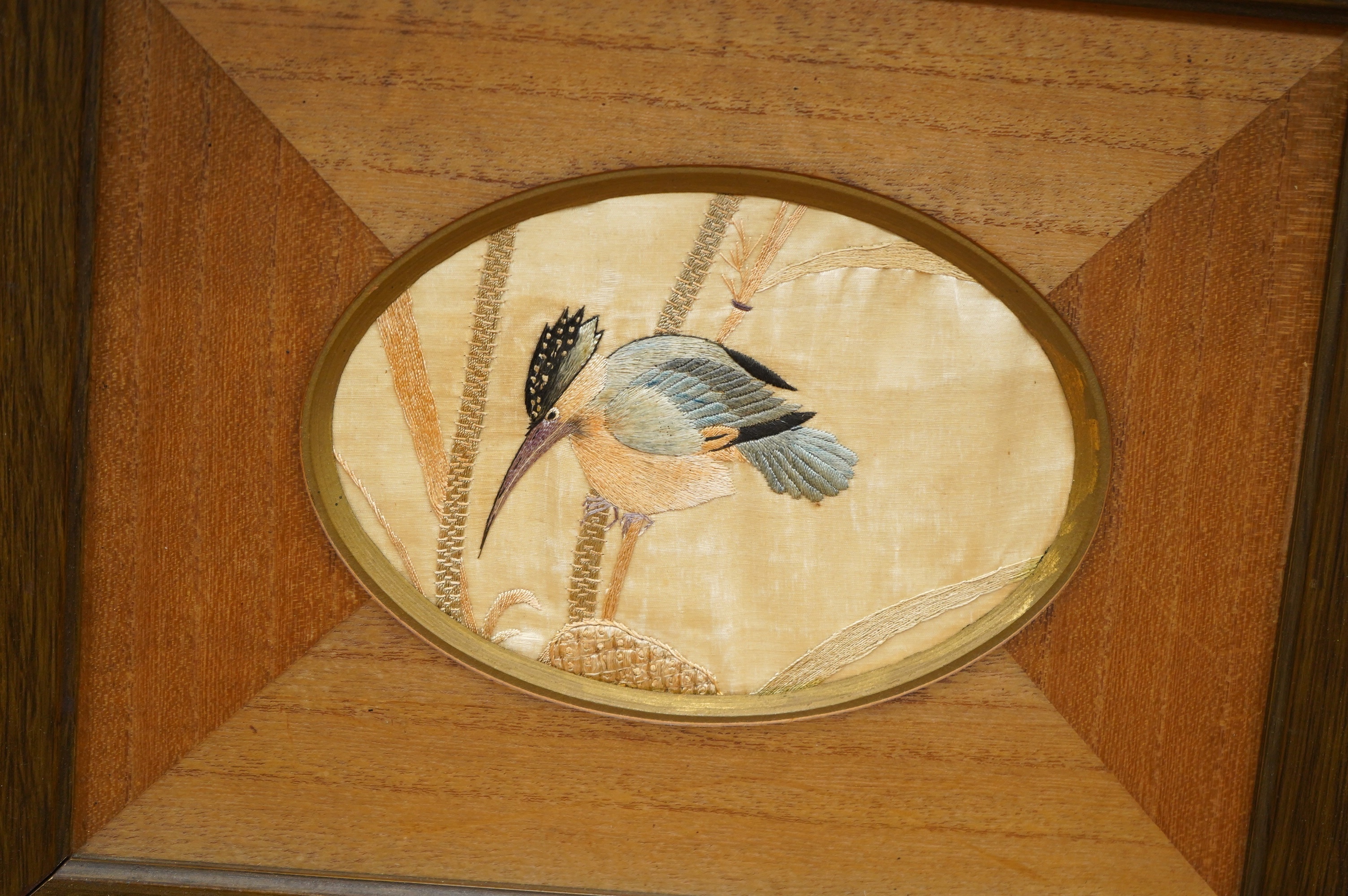 A pair of framed early 20th century Japanese oval silk embroideries of Kingfishers, embroidered on cream silk in pastel shades of silk thread, in a variety of stitches, various parts of each bird slightly couched giving